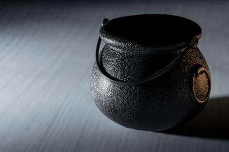 Black iron old cauldron scary prop for halloween used by witches to make brew, potions and poisonsの写真素材