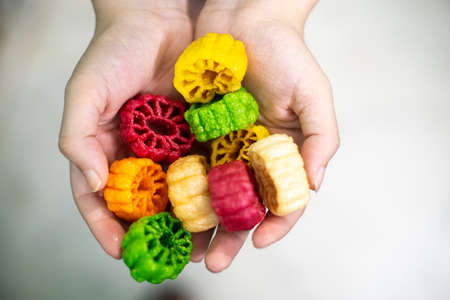 Young indian woman holding colorful fried food made of potato starch and sago called far far fryums which is a popular food in north india or a great snack. Shows an unhealthy fried snack with high empty calories that add to fat and heart diseaseの写真素材