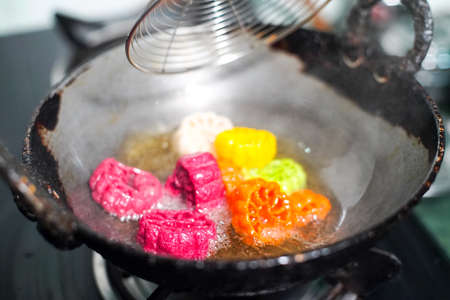 shot of colorful Fryums being deep fried in hot oil bubbling and sizzling with bubbles forming and size increasing of this popular north indian snack and street food. This sago and potato starch delicacy is a popular snack that is unhealthy but very tastyの写真素材