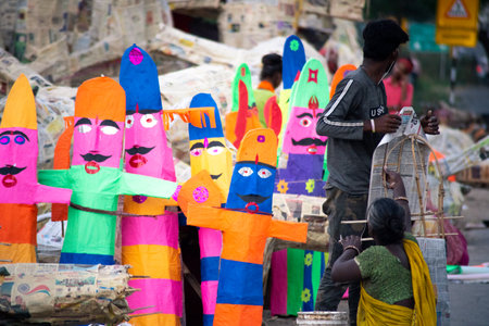 Gurgaon, delhi, India - circa 2020 : Street road side artisans workers labor craftsment working on multiple paper effigy statues of ravan the demon king who is burnt on the hindu festival of dussera as foretold in the ramayana. These craftsmen families buのeditorial素材