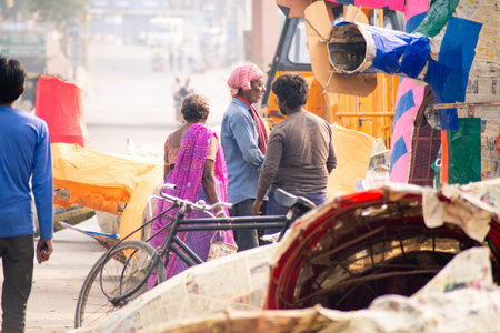economically poor old man and woman in unkempt clothes pasting colorful panels on a newspaper paper...