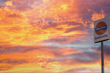 Signage of indian oil petrol pump shot against a monsoon clouds and blue sky showing indias largest petroleum manufacturer and petrol pump owner