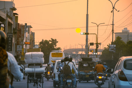 Crowded street filled with bikes, rickshaws, cars and autos shot during the dusk sunset sunrise showing the busy local streetsのeditorial素材