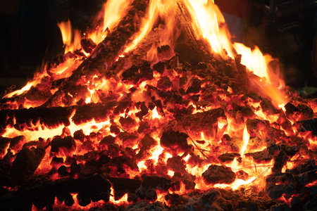 Close up macro shot of wood fire with log embers and flames coming out shot during the indian...