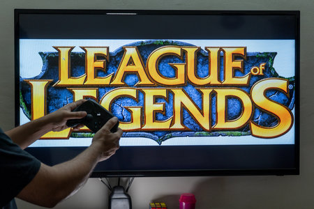 Man holding steam controller in front of a screen loading the popular RPG MMORPG league of legends a...