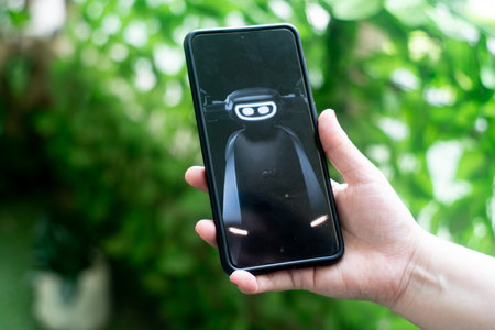Mobile phone smartphone showing website app bor booking Ola Electric new S1 electric vehicle scooter in India asia. With a young woman holding the phone outdoors against plantsのeditorial素材