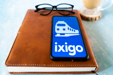 popular indian travel app ixigo on a mobile phone showing an blue cover and a train for hotel, travel and IRCTC bookingのeditorial素材