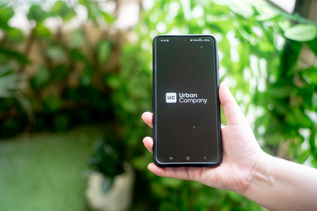 Urban Clap urban company on a mobile phone with garden in the background showing this starup app with home services, repairs and moreのeditorial素材