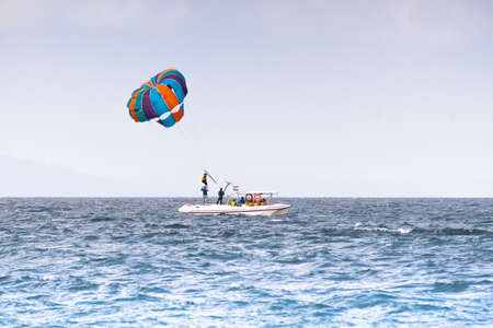 multiple boats in distance doing para gliding sailing while adventure sports like jet sking happening showing busy summer season in goa havelock andaman nicobar island indiaの写真素材