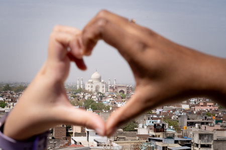 Couple making symbol of heart framing the Taj mahal the eternal symbol of love in Indiaの写真素材
