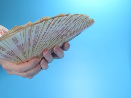 Woman's hands holding many Russian ruble five thousand banknotes, side view, copy space