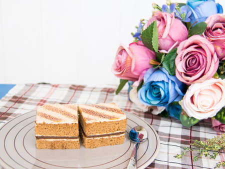Coffee cakes on a gray plate with rose and fabric.