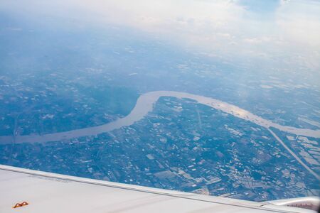 Airplane wing with city high view | beautiful natural land | transportation businessの写真素材