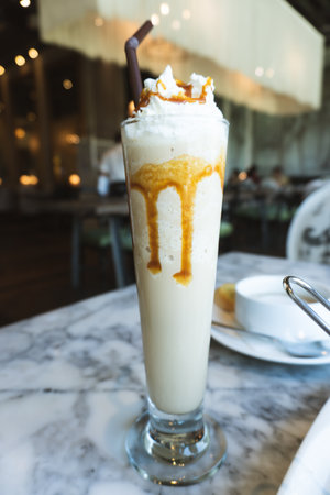 Iced coffee with whipped cream on table in cafe, stock photoの写真素材