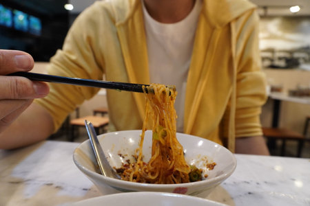 Man eating noodle with chopsticks in the restaurant, stock photoの写真素材