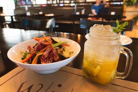 Fresh vegetable salad with ice in mason jar on table in restaurantの写真素材