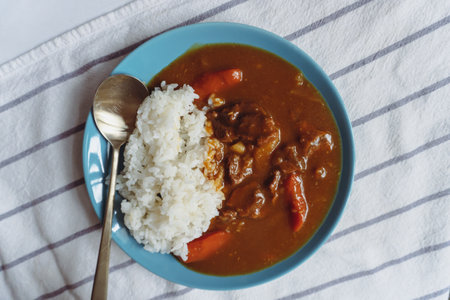 Japanese curry with rice in a blue bowl on a white tableclothの写真素材