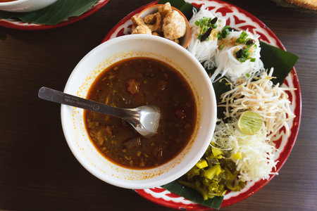 Thai spicy soup with rice vermicelli on wooden tableの写真素材