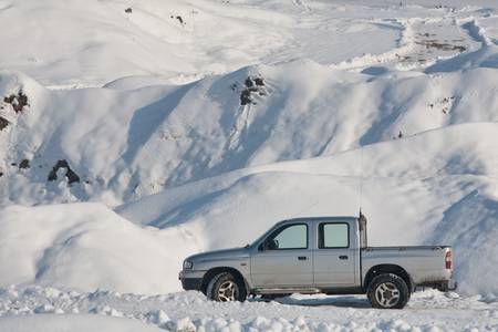  car in  winter sceneraio with marks on the road sugesting offroad capabilities