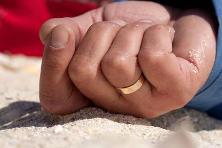 closeup of a married man\'s hand on the beach