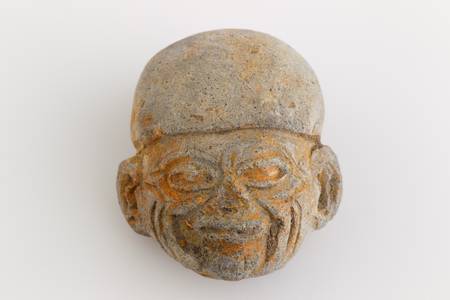 antique amulet from Valdivia culture representing an abstract beeing on white background. Part of La Tolita region, north of Ecuador in Esmeralda province.の写真素材