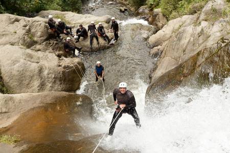 adult man desceding an ecuadorian waterfall in a corect position