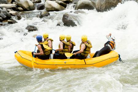 a group of men and women, with a guide, white water rafting on the Pastaza river, Ecuador