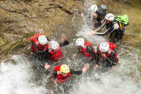 group of adventurous people fooling around in a natural poolの写真素材