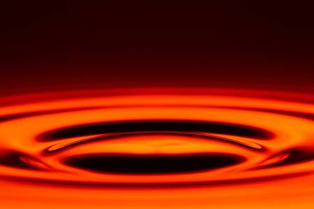 symetrical swirl from the water level against red backroundの写真素材