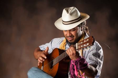 rastafarian man playing classic guitarの写真素材