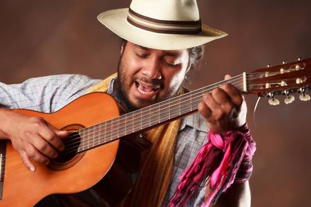 rastafarian man playing classic guitar