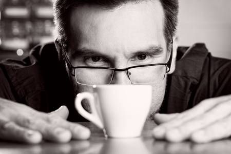 sommelier examining coffee cream in espresso cupの写真素材