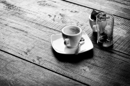 espresso empty cup on wooden table top, monochrome image.の写真素材