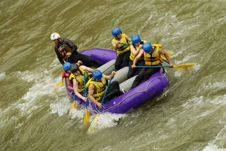 a group of men and women, with a guide, white water rafting on the patate river, ecuador