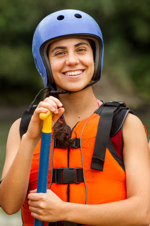 portrait of smiling young lady wearing white water rafting equipmentの写真素材