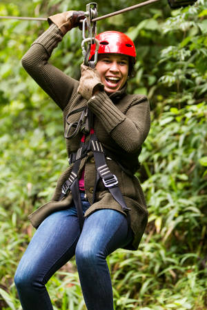 adult slime afro woman closeup portrait on zipline in ecuadorian rainforest, nearby banos de agua santaの写真素材