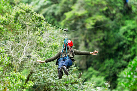adult slime afro woman closeup portrait on zipline in ecuadorian rainforest, nearby banos de agua santaの写真素材