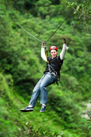 adult male tourist wearing casul clothing on zip line or canopy experience in ecuadorian rain forest