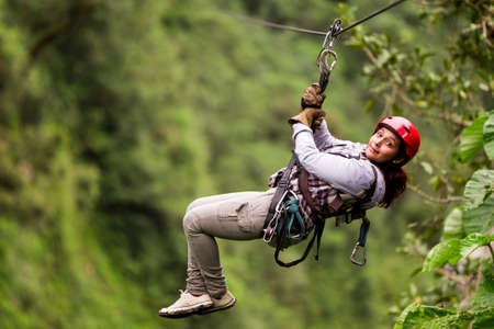 adult tourist wearing casul clothing on zip line trip, selective focus against blured forestの写真素材