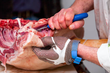 Butcher That Cuts Fresh Pork Wearing Protective Glovesの写真素材