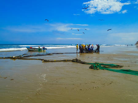 SAN CLEMENTE, ECUADOR - APRIL 7, 2015: Unidentified fishermen on San Clemente beach in Ecuador. San Clemente is a fishing village with approximately 2000 inhabitants.のeditorial素材