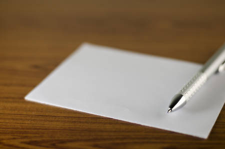 pen with white paper on wooden backgroundの写真素材