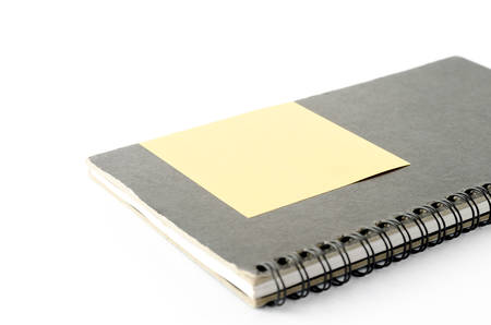 notebook and sticky note on a white backgroundの写真素材
