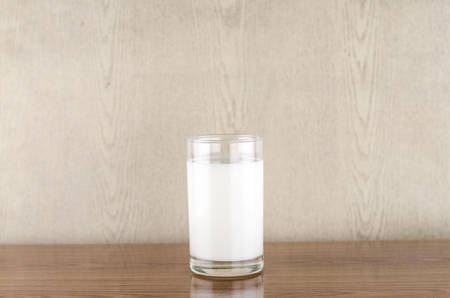 milk in a glass on wood backgroundの写真素材