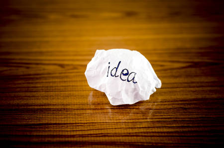 writing idea word on crumpled on wood backgroundの写真素材