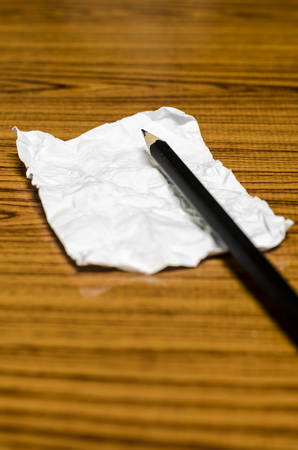 paper scrap with pencil on wood backgroundの写真素材