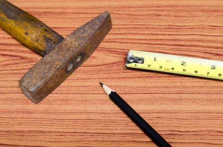 hammer measuring tape and pencil concept tools on wood backgroundの写真素材