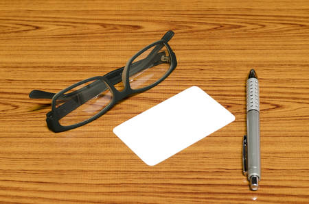 business card and pen with glasses on wood backgroundの写真素材
