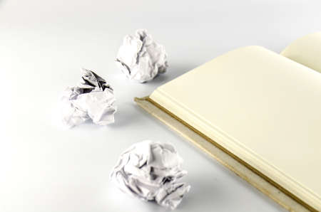 crumpled paper and notebook on a white background