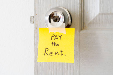 sticky note write a message pay the rent on the latch doorの写真素材